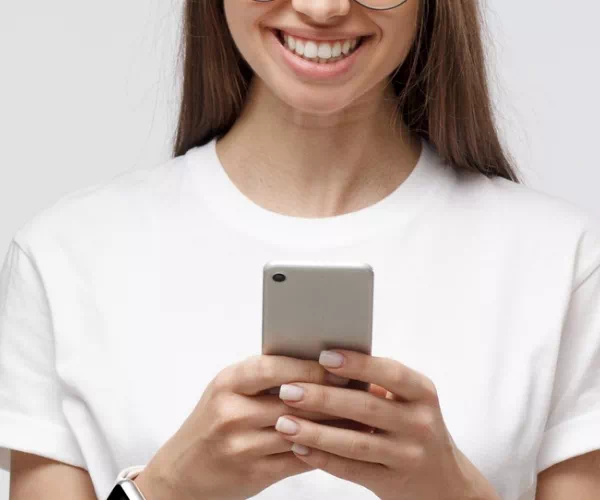 Uśmiechnięta kobieta korzystająca ze smartfona